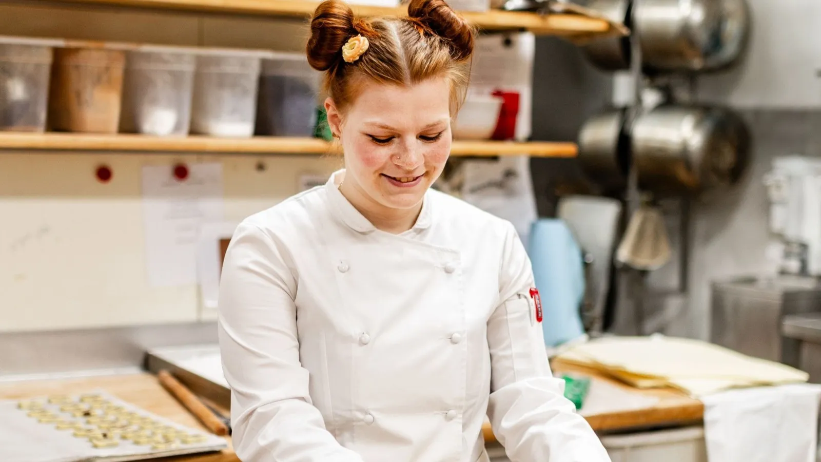 Foto von Konditormeisterin Theresa Mayer in ihrer weißen Berufskleidung während der Arbeit.